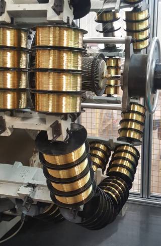 Several axis of brass coated wires on the machine.